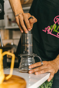 man plunging an aeropress coffee maker with trading post coffee 